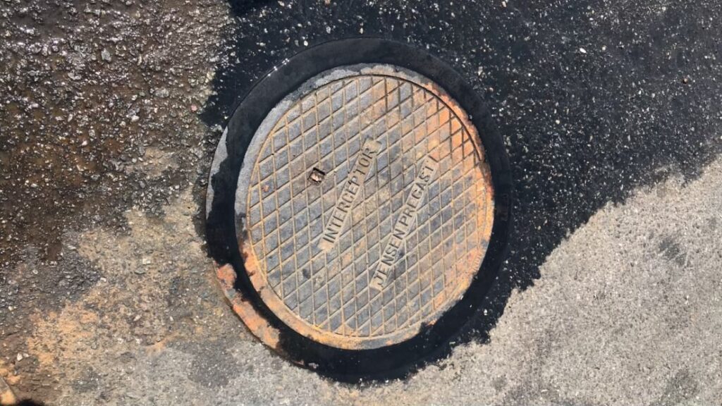 Grease interceptor lid open during cleaning service at a commercial kitchen