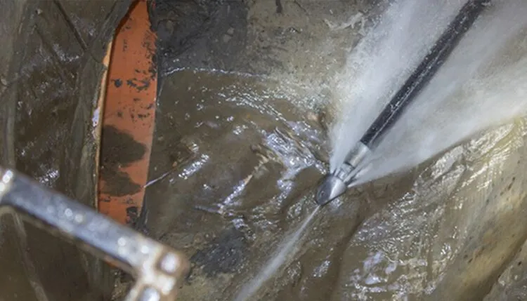 Commercial hydro jetting removing grease buildup from kitchen drain lines in Orange County