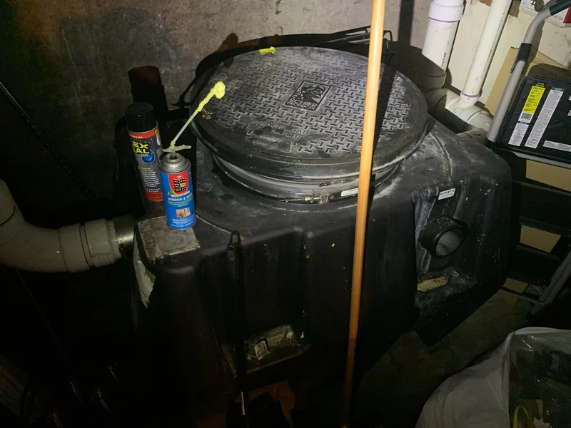 Technician repairing a damaged underground grease trap in a commercial kitchen in Orange County