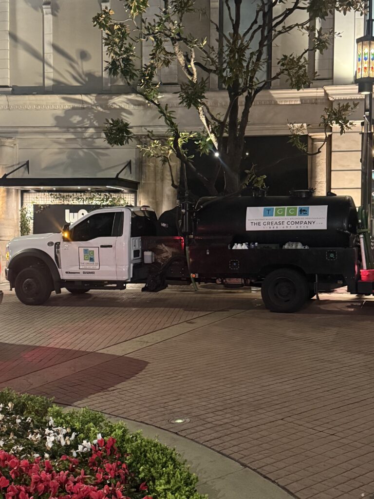 Grease trap cleaning truck parked outside a restaurant in Orange County during professional service