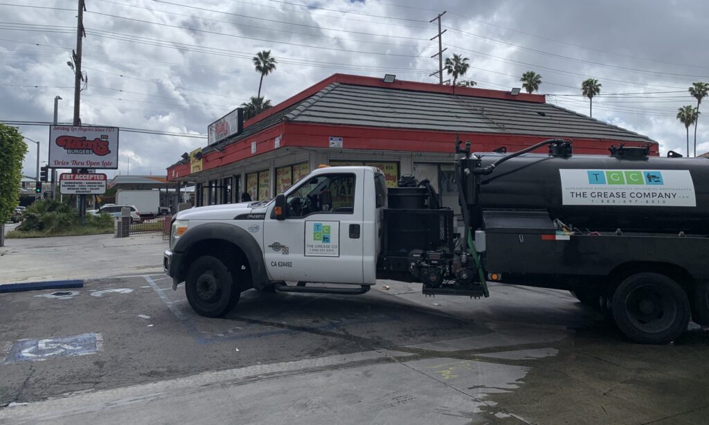 Grease interceptor cleaning service truck from Orange County Grease Co on site at a commercial kitchen