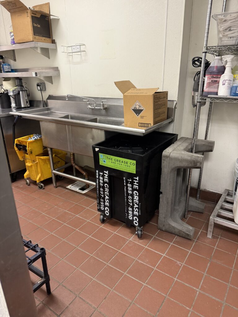 Grease trap installed under a commercial kitchen sink in an Orange County restaurant