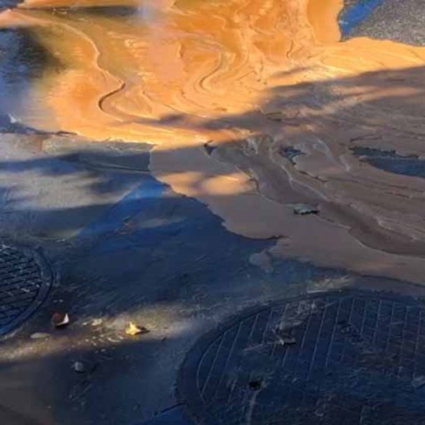 Overflowing underground grease trap lid in Huntington Beach requiring immediate cleaning to prevent sewer backups and kitchen hazards.