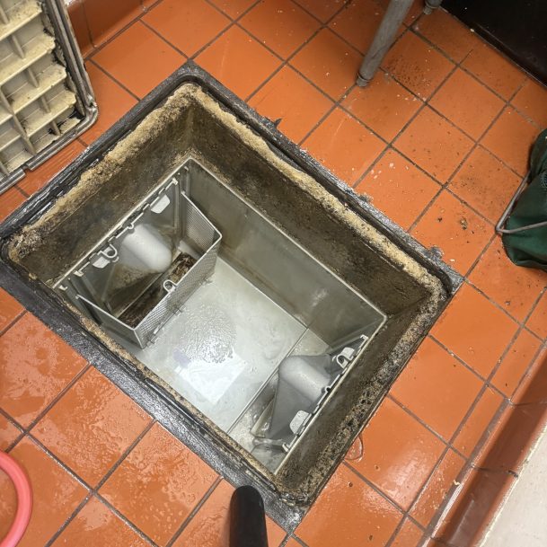 Professional Newport Beach grease trap cleaning in a commercial kitchen